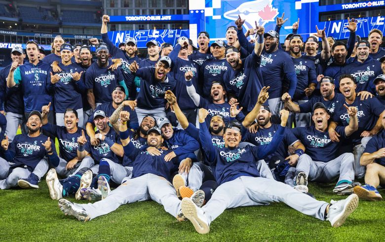 The Mariners celebrate their 10-9 AL wild-card series victory over Toronto. (Dean Rutz / The Seattle Times)